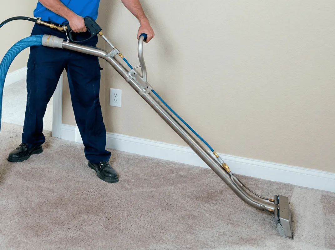 Professional operating a liquid removal machine on a carpeted floor in Overland Park, KS